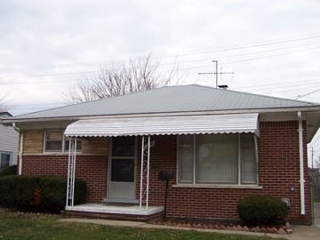 St. Clair Shores house for rent - A house with a red brick exterior and a white porch.