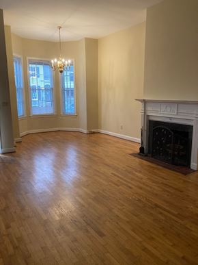 Washington apartment for rent - A room with a fireplace and a chandelier.