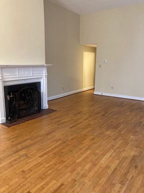Washington apartment for rent - A room with a fireplace and wood flooring.