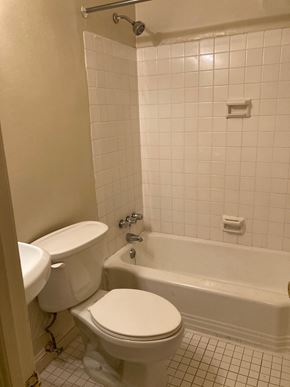 Washington apartment for rent - A white toilet and bathtub in a bathroom with white tiles.