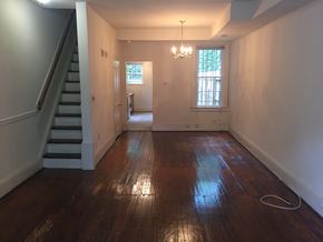 Washington apartment for rent - A room with wooden floors and a staircase on the left side.