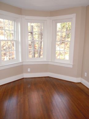 Washington apartment for rent - A room with wood floors and three windows.