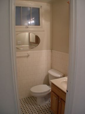 Washington apartment for rent - A white toilet sits in a bathroom with a sink and mirror.