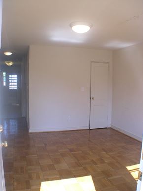 Washington apartment for rent - A room with a wooden floor and a white door.