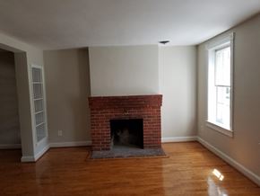 Washington apartment for rent - A room with a fireplace and wooden floors.