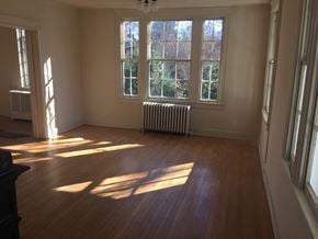 Washington apartment for rent - A room with wooden floors and a large window with sunlight shining through.
