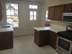 Washington apartment for rent - A kitchen with white appliances and brown cabinets.
