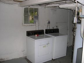 Washington apartment for rent - A white appliance with a black top sits in a room with a window and pipes.