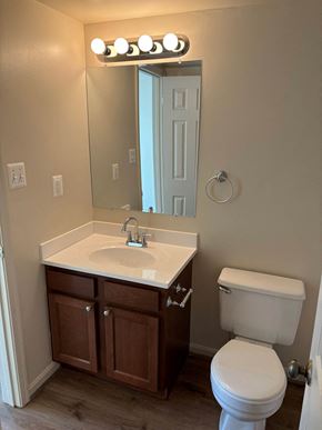 Vienna apartment for rent - A bathroom with a white toilet, sink, and mirror.