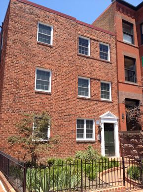 Washington apartment for rent - A red brick building with a black iron fence in front.