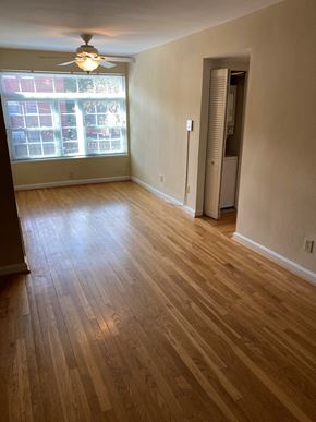 Washington apartment for rent - A room with a ceiling fan and a window with blinds.
