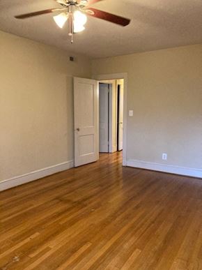 Washington apartment for rent - A room with a ceiling fan and wooden floors.
