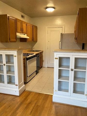 Washington apartment for rent - A kitchen with white cabinets and a white door.