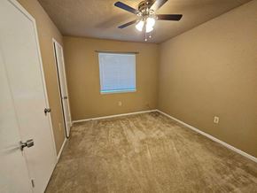 Houston house for rent - an empty bedroom with a ceiling fan and a door