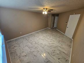 Houston house for rent - a living room with marble flooring and a ceiling fan