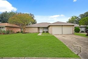 Houston house for rent - a house with a driveway and lawn in front of it