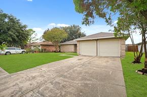 Houston house for rent - the driveway of a house with a garage and a lawn