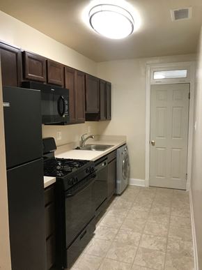 Washington apartment for rent - A kitchen with black appliances and brown cabinets.