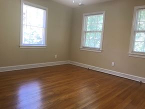 Washington apartment for rent - A room with wooden floors and three windows.