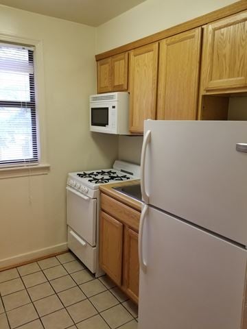Washington apartment for rent - A kitchen with a white refrigerator, white stove, and white microwave.