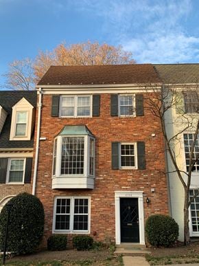 Mclean apartment for rent - A red brick house with a black door and a small window with a white frame.