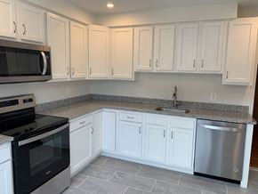 Mclean apartment for rent - A kitchen with white cabinets and a black stove top oven.