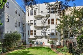 San Francisco apartment for rent - A white apartment building with a green lawn in front.