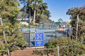 San Francisco apartment for rent - A sign with a blue background and white text is in front of a playground.