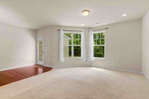 Morrisville house for rent - an empty living room with two windows and a rug