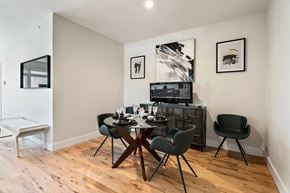 Newark apartment for rent - a dining room with a wooden table and chairs and a television