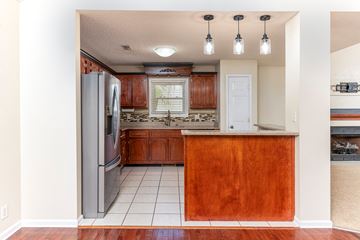 Clarksville house for rent - a kitchen with wooden cabinets and a stainless steel refrigerator