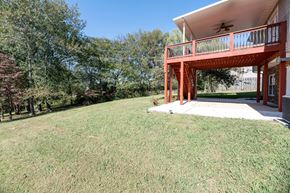 Clarksville house for rent - a backyard with a deck and a house with a yard and trees