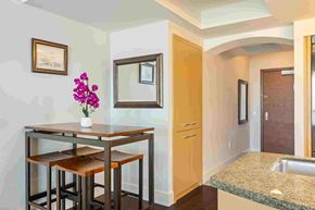 Honolulu apartment for rent - A kitchen with a table and chairs and a vase of flowers.