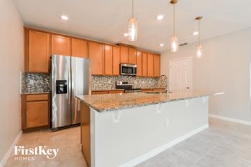 Groveland house for rent - a kitchen with granite counter tops and stainless steel refrigerator
