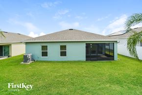 Groveland house for rent - a light blue house with a grass yard and a backdoor