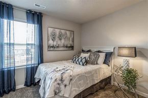 Waukee apartment for rent - A bedroom with a bed, a lamp, and a picture on the wall.