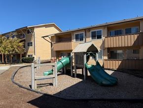 Portland apartment for rent - A playground with a green slide in front of a building.