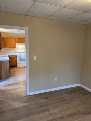 Hazen apartment for rent - A kitchen with a refrigerator, sink, and cabinets is visible through an open door.