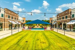 Columbus apartment for rent - A large grassy area with a pool and buildings on either side.