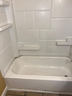 Long Beach apartment for rent - a bathroom with a white tub and a white tiled wall