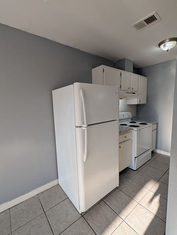 Long Beach apartment for rent - A white refrigerator is in a kitchen with a stove top oven.