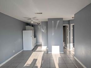 Long Beach apartment for rent - A room with a white refrigerator and a ceiling fan.