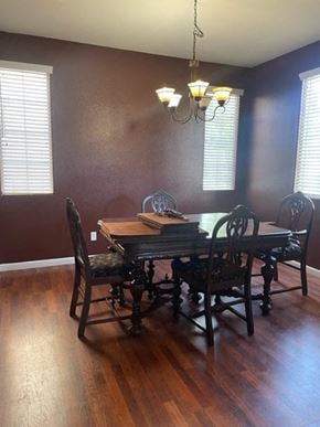 Santa Maria house for rent - A brown wooden dining table with four chairs and a chandelier.