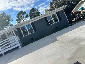 Fayetteville apartment for rent - a gray house with a white porch and a driveway