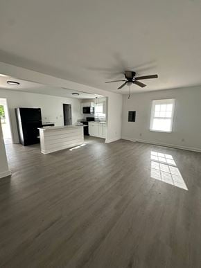 Fayetteville apartment for rent - an empty living room with a ceiling fan and a kitchen