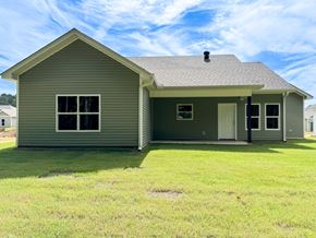 Benton house for rent - a green house with a lawn and a blue sky
