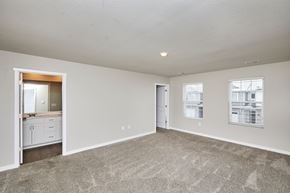 Waukee apartment for rent - A spacious empty room with a carpeted floor and a doorway leading to another room.