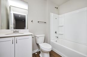 Waukee apartment for rent - A white bathroom with a toilet, sink, and bathtub.