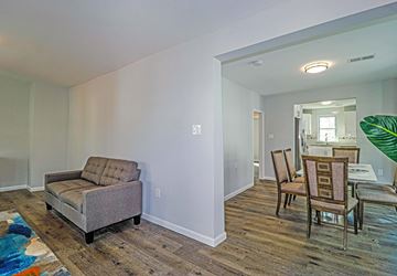Collingswood apartment for rent - A living room with a grey couch and wooden floors.