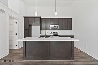 West Des Moines apartment for rent - A modern kitchen with dark brown cabinets and white countertops.